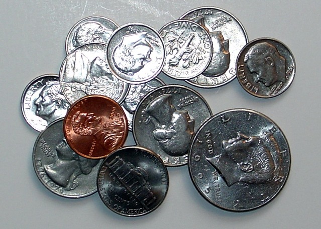 spousta kovových mincí na hromádce na stole