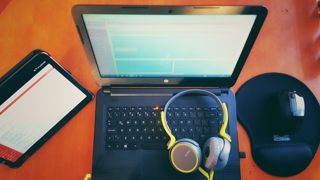 počítač, sluchátka, myš a tablet na stole